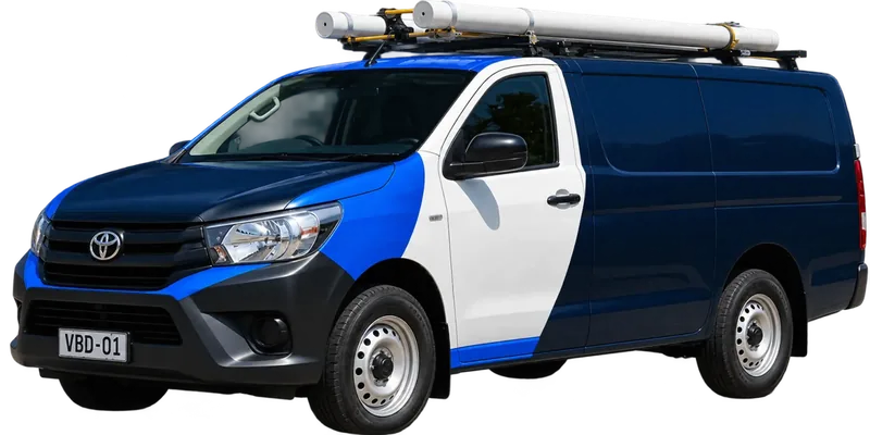 A licensed Parramatta plumbing van loaded with pipe on the roof rack